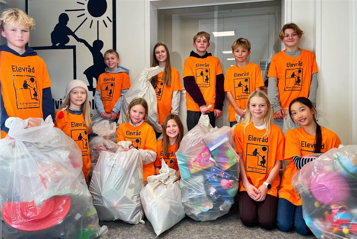 Elever samlet med plastsekker fulle av leker, klær og andre ting - Klikk for stort bilde