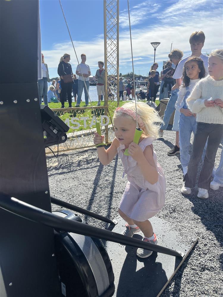 Signe Berge på snart seks år testet aktivitetene til CrossFit Grimstad i Byhaven. Her tester hun armstyrken sin, flere barn står i kø bak henne.  - Klikk for stort bilde